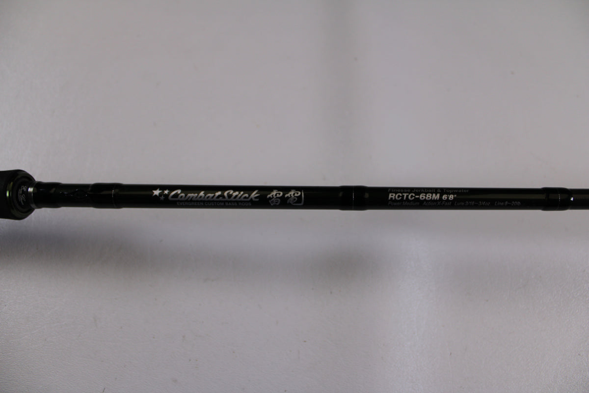 A close-up of the Evergreen Combat Stick RCTC-68M, a used casting rod in excellent condition, shows its model details and "Combat Stick" text on the shaft against a white background—ideal for our Rod and Reel Trade-In Program.