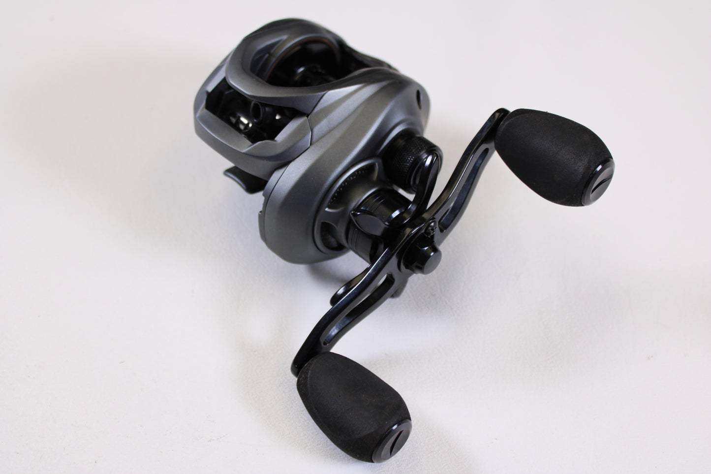 A close-up of the Fitzgerald VLD 10 FVLD-801L 8.1:1 LH—Used Casting Reel in very good condition, showing black and silver design with two large handle grips on a plain white background—ideal for upgrading your fishing gear.