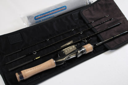 A Shimano Cardiff Steam Premium B48UL-G/4 4'8" Ultra Light 4pc Used Casting Rod in mint condition, with a cork handle and black accents, is displayed on a black case beside its tube—ideal for our Rod and Reel Trade-In Program.