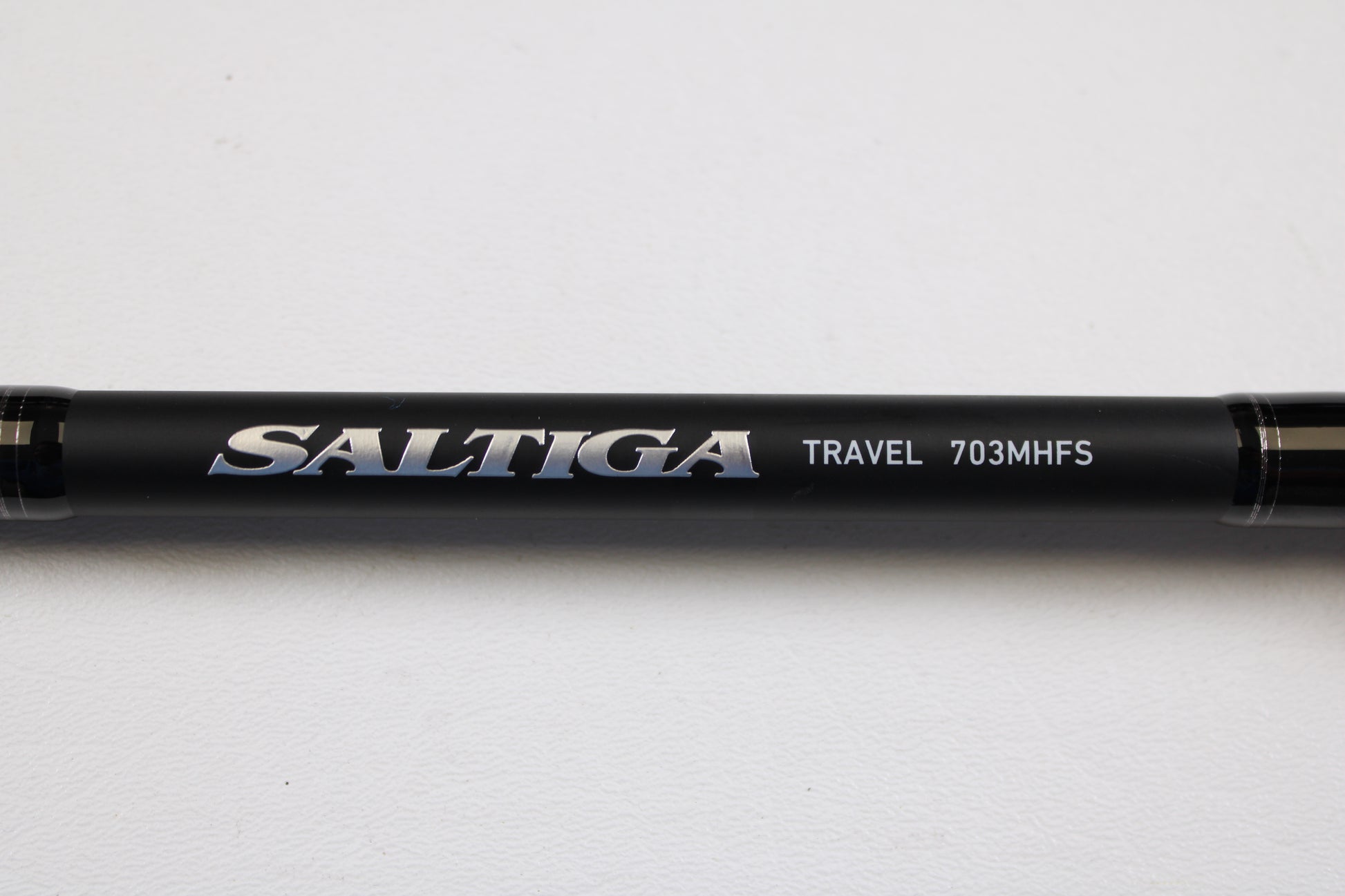 Close-up of a Daiwa Saltiga Inshore Travel SATRIN703MHFS 7'0" Medium Heavy 3pc Used Spinning Rod in excellent condition, shown against a white background—ideal for our Rod and Reel Trade-In Program if you want to upgrade.