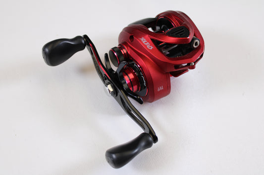 A close-up of the Favorite Fishing Soleus Red SLSR7R 7.3:1 RH Used Casting Reel in good condition, shown with black dual handles—ideal for trading in used gear and earning store credit via our Rod and Reel Trade-In Program.