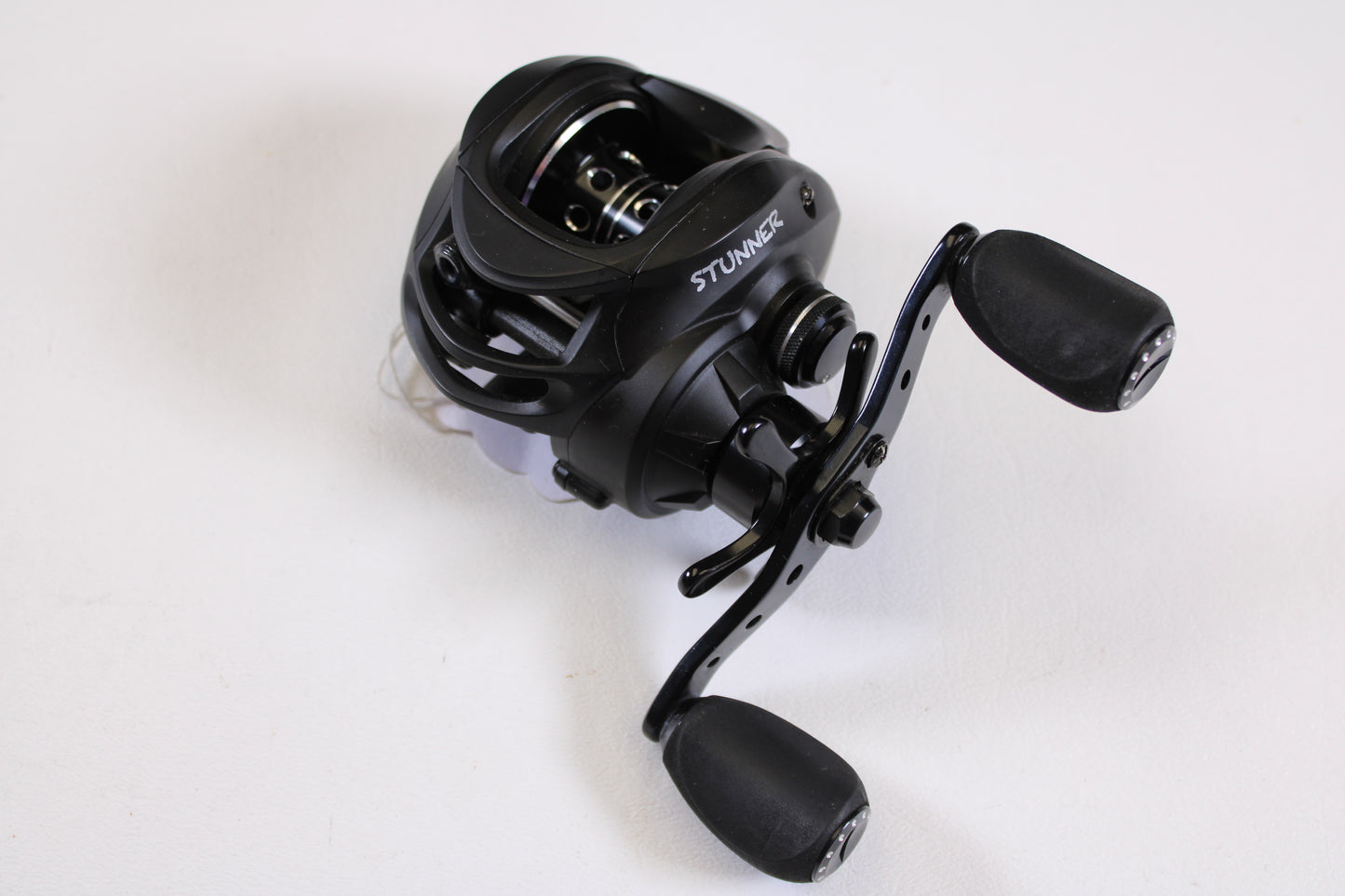 A Fitzgerald Stunner 6.3:1 LH used casting reel in excellent condition, featuring dual ergonomic handles, shown on a plain white surface—ideal for upgrades with our rod and reel trade-in program.