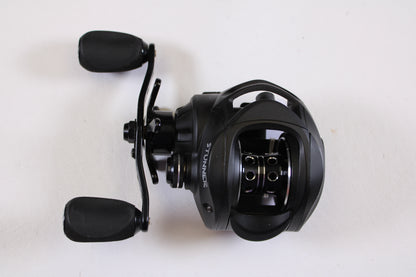 A Fitzgerald Stunner 6.3:1 LH used baitcasting reel in excellent condition, black with two handles, is shown from above on a white background—the word "STUNNER" displayed on the side, ideal for anglers seeking quality used gear.