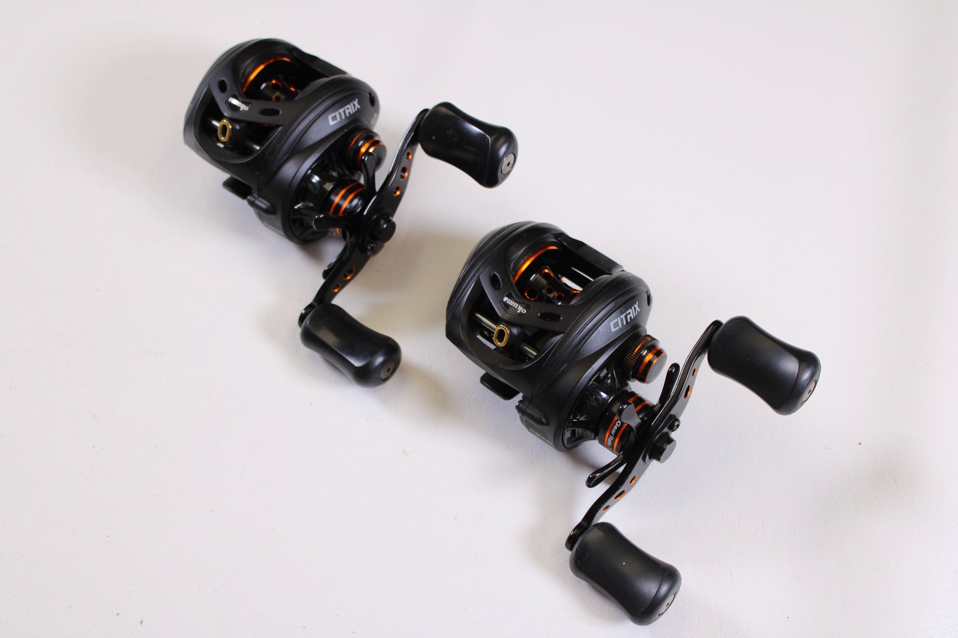 Two Okuma Citrix Ci-273LXa 7.3:1 LH used baitcasting reels (Qty: 2, very good condition) are displayed diagonally on a white surface—an excellent choice for upgrading through our rod and reel trade-in program.