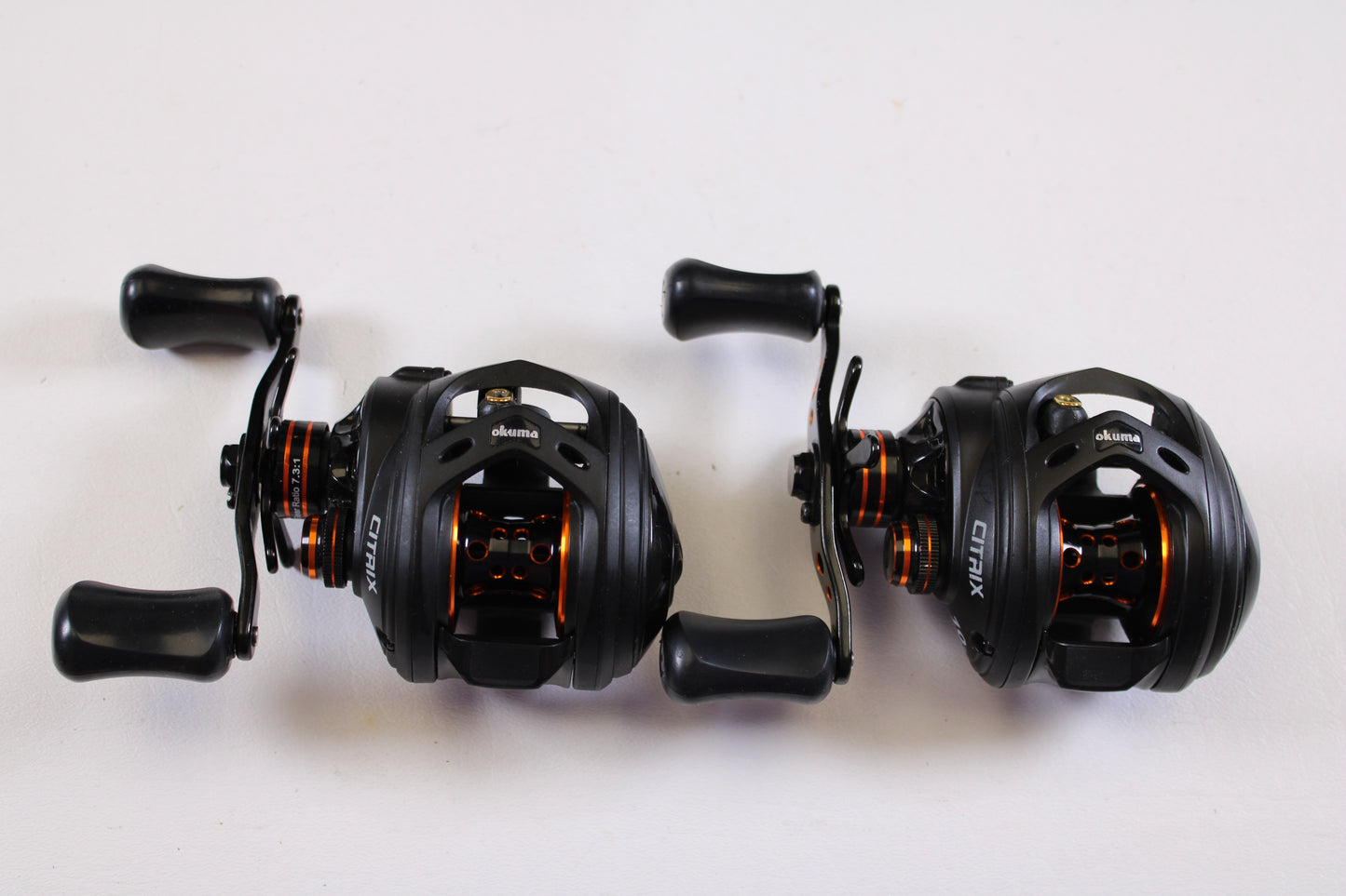Two Okuma Citrix Ci-273LXa 7.3:1 LH used casting reels (Qty: 2, very good condition) rest side by side—great for trading in or earning store credit with our rod and reel trade-in program.