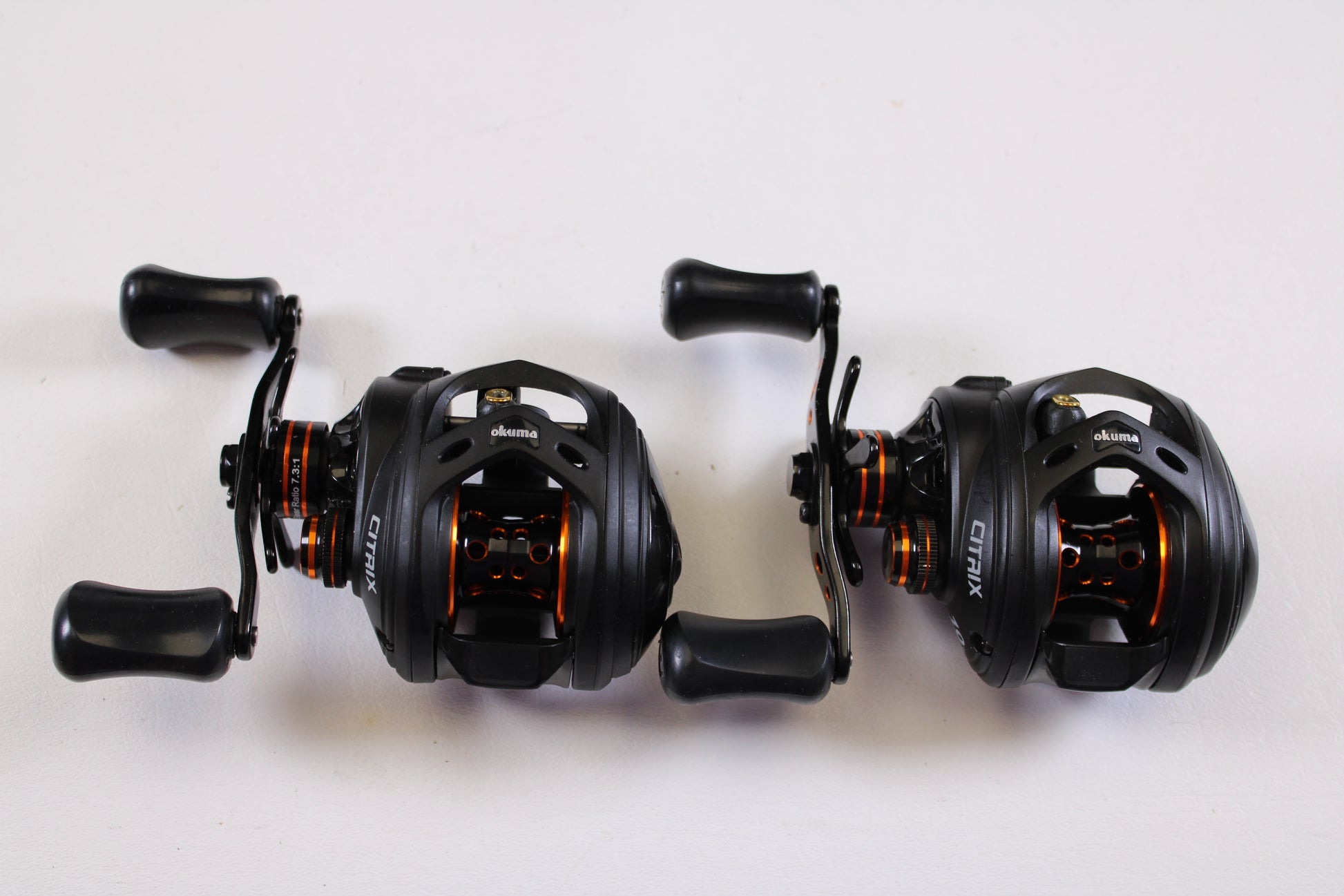 Two Okuma Citrix Ci-273LXa 7.3:1 LH used casting reels (Qty: 2, very good condition) rest side by side—great for trading in or earning store credit with our rod and reel trade-in program.
