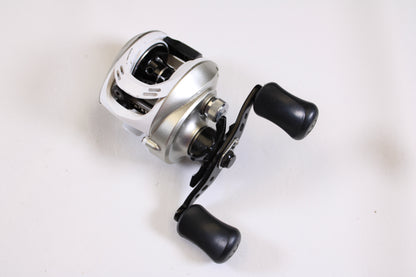 A close-up of the Okuma Stratus V 6.4:1 LH casting reel in good condition, featuring two large black handles on a white background—ideal for upgrading with our rod and reel trade-in program for store credit.