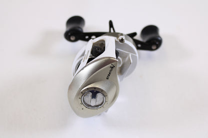 A used Okuma Stratus V 6.4:1 LH casting reel in good condition stands vertically on a white background—perfect for anglers seeking an upgrade through a rod and reel trade-in or exchanging used gear for store credit.