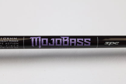 Close-up of a black St. Croix Mojo Bass JOC710XHM Mag Cranker 7'10" XH used casting rod in mint condition, featuring purple "Mojo Bass" text and symbols on white background. Trade in your gear for store credit through our Rod and Reel Trade-In Program.