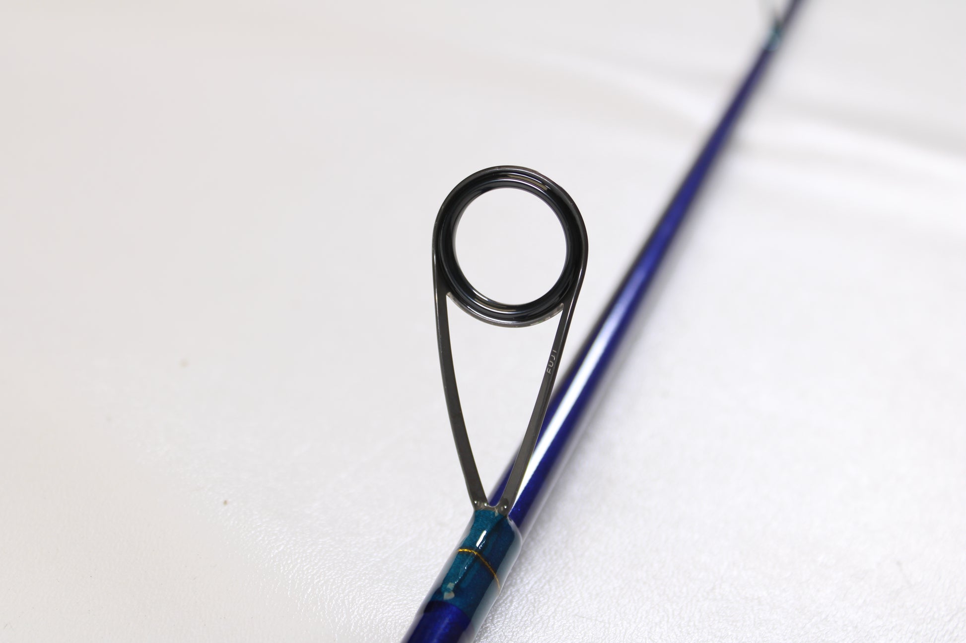 Close-up of a St. Croix Legend Tournament Inshore ITLS76MF 7'6" medium used spinning rod in mint condition, highlighting a single black line guide on a plain white background—ideal for our rod and reel trade-in program.