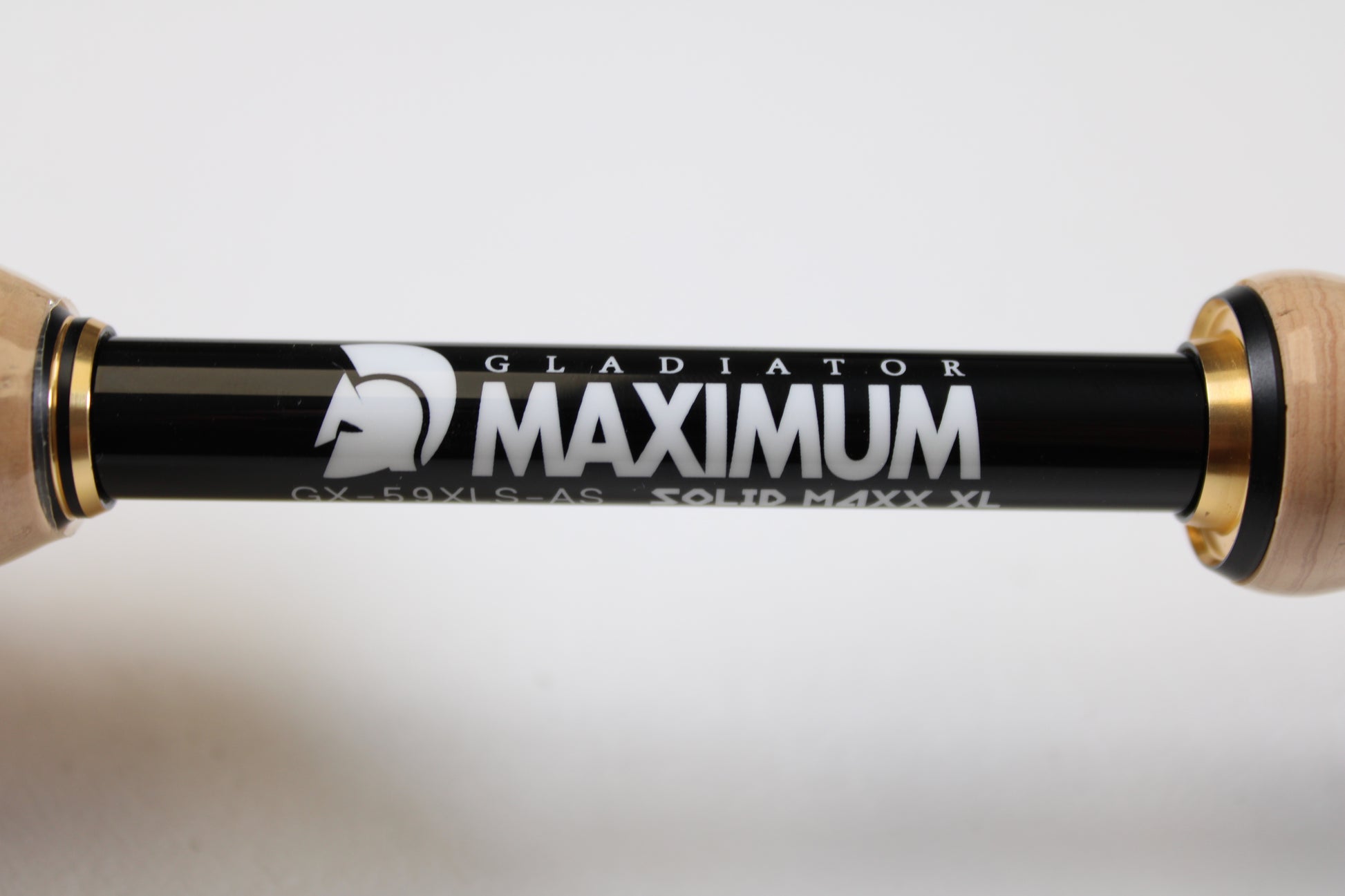 Close-up of a Raid Japan Gladiator Maximum GX-59XLS-AS Solid Maxx XL 5'9" Extra Light Used Spinning Rod in mint condition, black with gold accents and helmet logo, shown horizontally—ideal for our Rod and Reel Trade-In Program.
