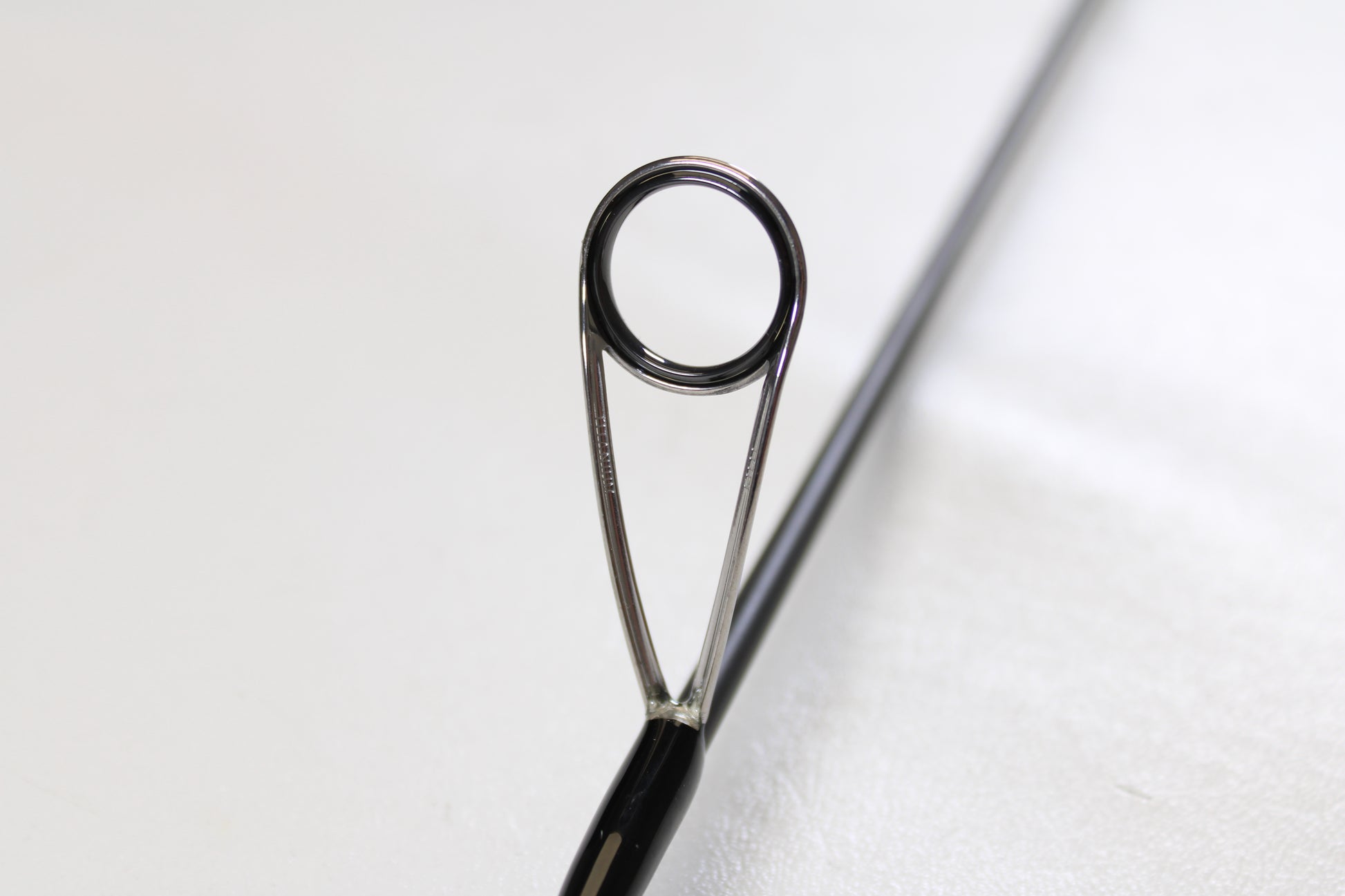 Close-up of the eyelet and metal frame on the Raid Japan Gladiator Maximum GX-59XLS-AS Solid Maxx XL 5'9" Extra Light Used Spinning Rod—shown in mint condition, perfect for our Rod and Reel Trade-In Program.