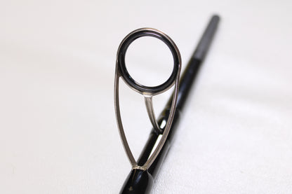 Close-up of the metal guide ring on a Century SlingShot SS 1265 10'6" 2 Piece Used Spinning Rod in excellent condition, with the rod extending out of focus—ideal for highlighting quality gear in our Century trade-ins.