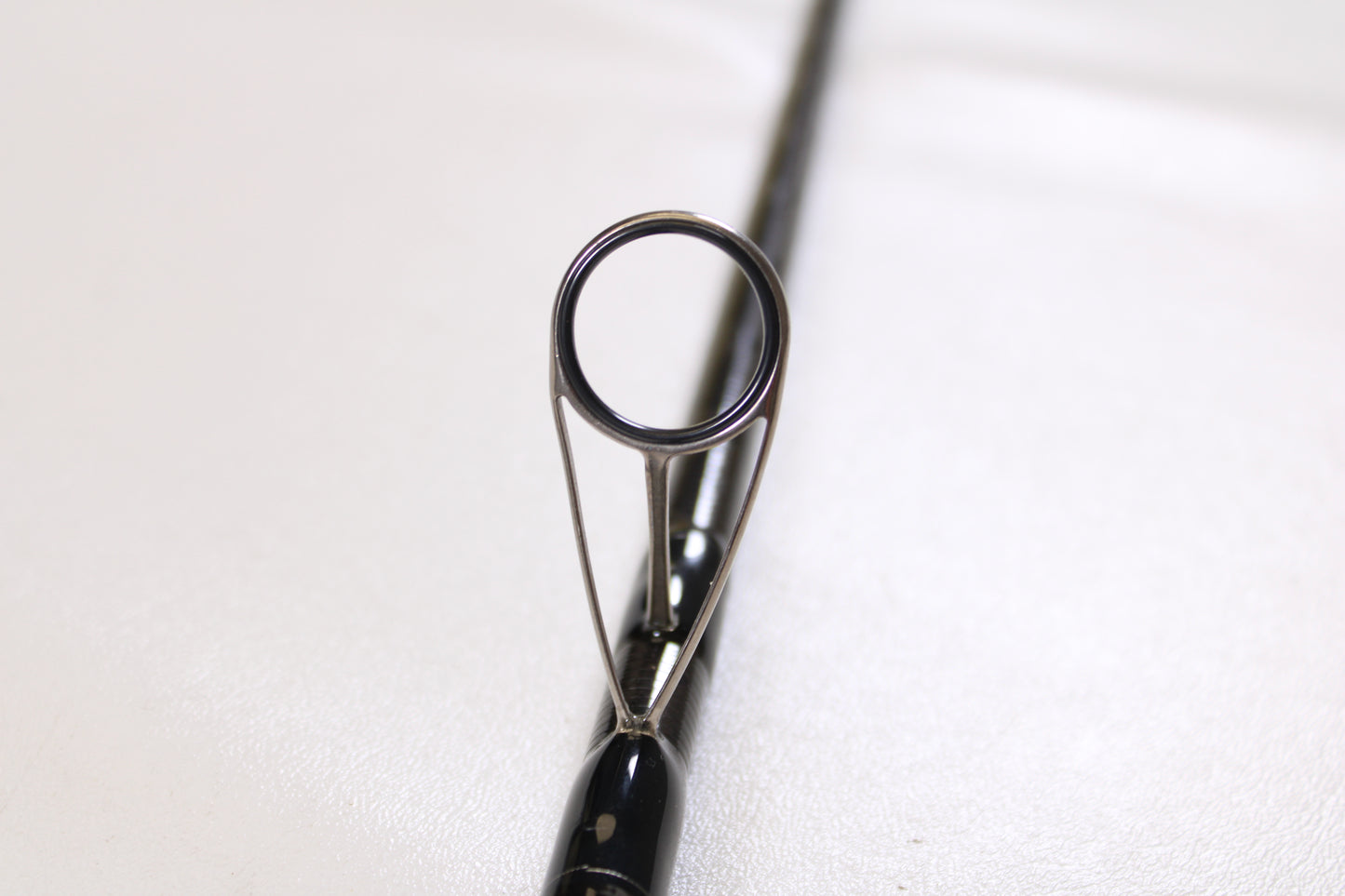 Close-up of the Century SurfMachine SM10L 10'0" spinning rod’s guide ring against a white background, perfect for upgrading through our Rod and Reel Trade-In Program for valuable store credit on used gear.