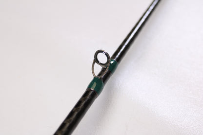 Close-up of a G. Loomis Conquest CNQ 783C MBR 6'6" Medium Heavy Used Casting Rod in excellent condition, featuring a metal guide ring with green thread, perfect for our Rod and Reel Trade-In Program. Shown on a plain white background.