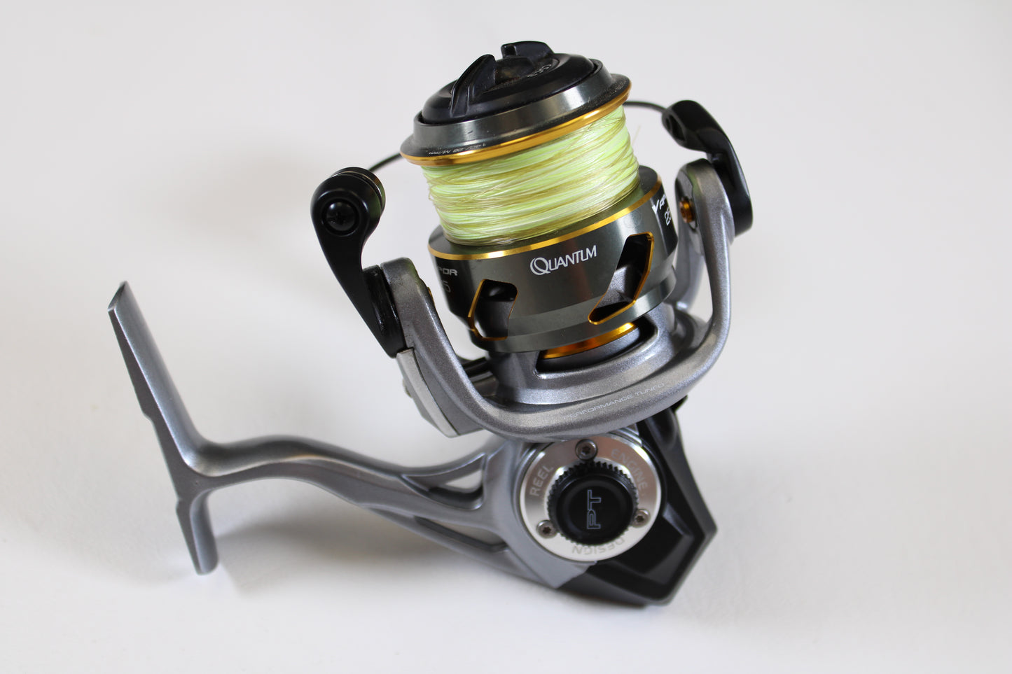 A close-up of a Quantum Vapor PT VP25XPT 6.0:1 spinning reel in excellent used condition, shown with yellow fishing line—ideal for upgrading through our Rod and Reel Trade-In Program for store credit.