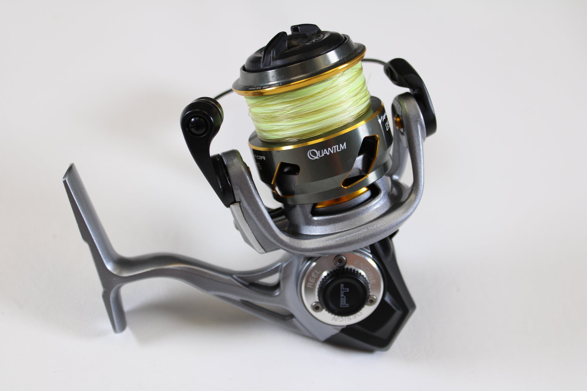 A close-up of a Quantum Vapor PT VP25XPT 6.0:1 spinning reel in excellent used condition, shown with yellow fishing line—ideal for upgrading through our Rod and Reel Trade-In Program for store credit.