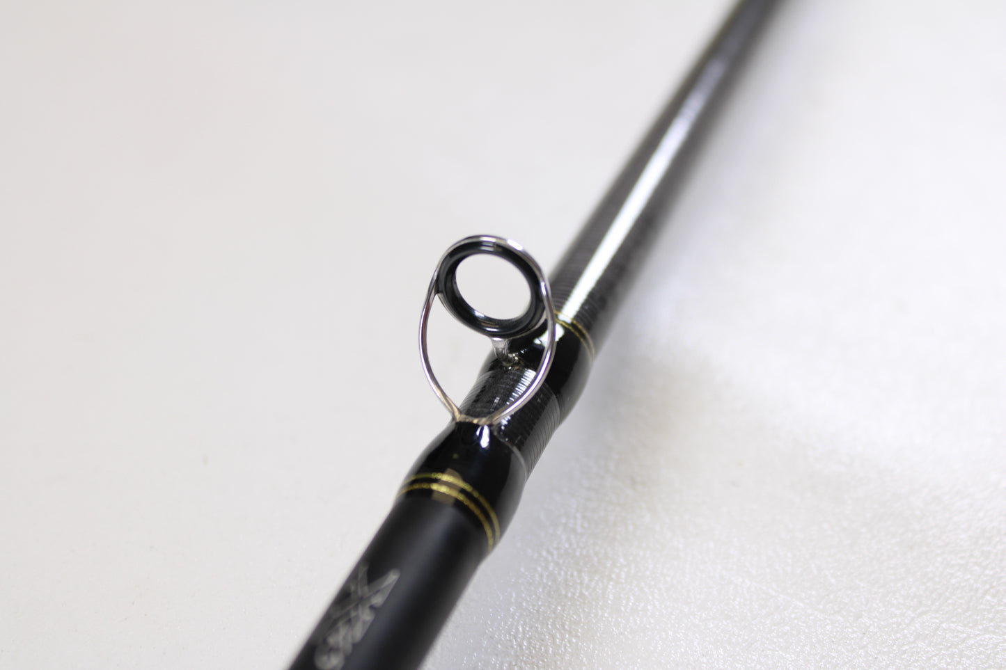 Close-up of the Daiwa Tatula TAT761HFB 7'6" Heavy Used Casting Rod in excellent condition, highlighting its guide ring with metallic finish and black accents—upgrade today with our Rod and Reel Trade-In Program for store credit.