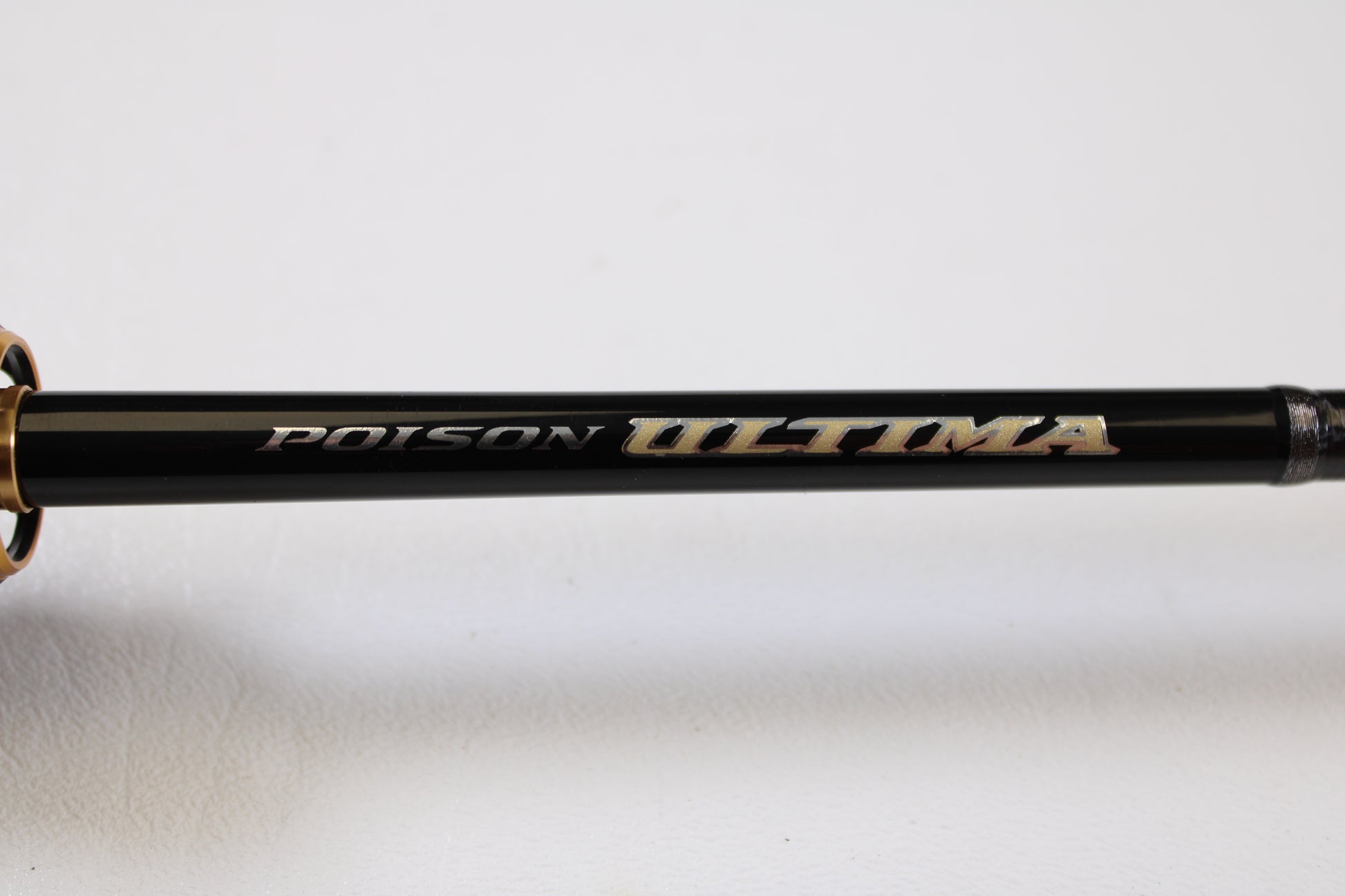 Close-up of a Shimano Poison Ultima 162L-S 6'2" Light Used Casting Rod in very good condition, with branding in metallic letters—upgrade today through our Rod and Reel Trade-In Program for store credit on your used gear.