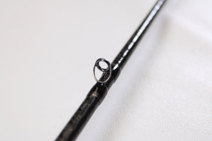 Close-up of a Shimano Poison Ultima 162L-S 6'2" Light - Used Casting Rod in very good condition, highlighting the metal guide ring against a white background. Trade in your used Shimano gear for store credit with our Rod and Reel Trade-In Program!.