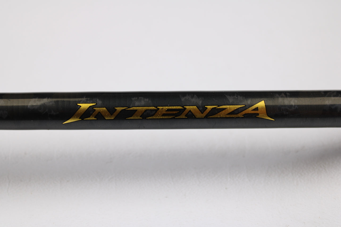 A close-up of a Shimano Intenza A NTZC72MHA 7'2" Medium Heavy Used Casting Rod in good condition, featuring gold "INTENZA" lettering on black—great for used gear fans or those seeking store credit via our trade-in program.