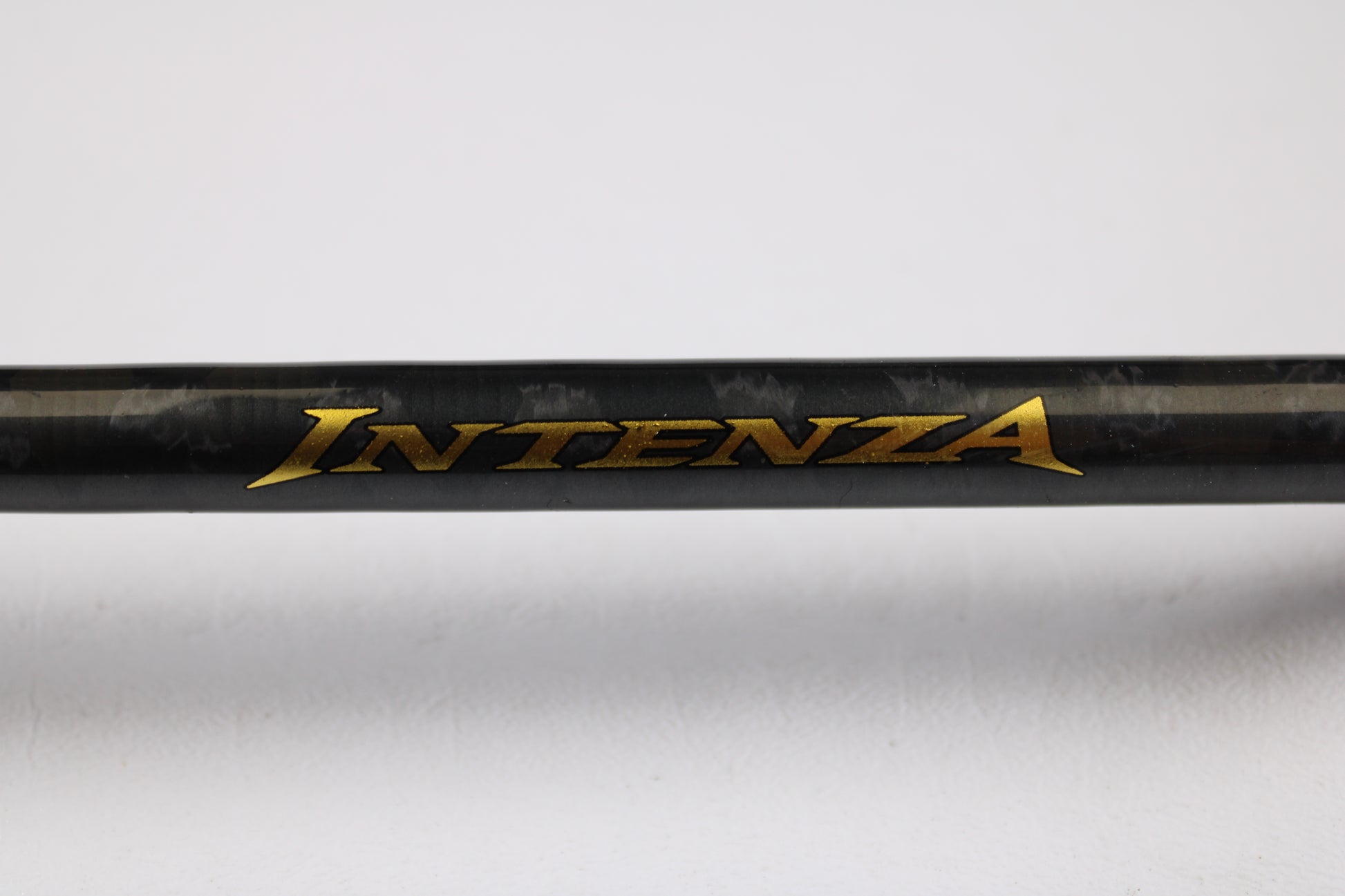 A close-up of a Shimano Intenza A NTZC72MHA 7'2" Medium Heavy Used Casting Rod in good condition, featuring gold "INTENZA" lettering on black—great for used gear fans or those seeking store credit via our trade-in program.