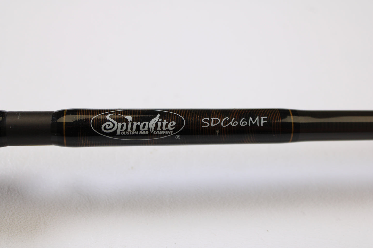 Close-up of the Spiralite Defiant SDC66MF 6'6" Medium used casting rod in excellent condition, showing the brand logo and model number in white—ideal for upgrading your tackle or finding quality used gear.