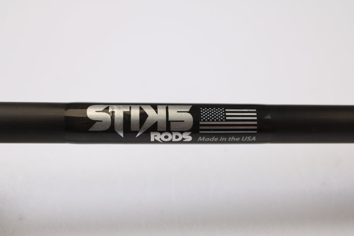 A close-up of a black Stik5 Elevate Series The One 7'3" Medium Heavy casting rod in excellent used condition, labeled "Stik5," with an American flag and "Made in the USA"—eligible for our trade-in program to earn store credit.