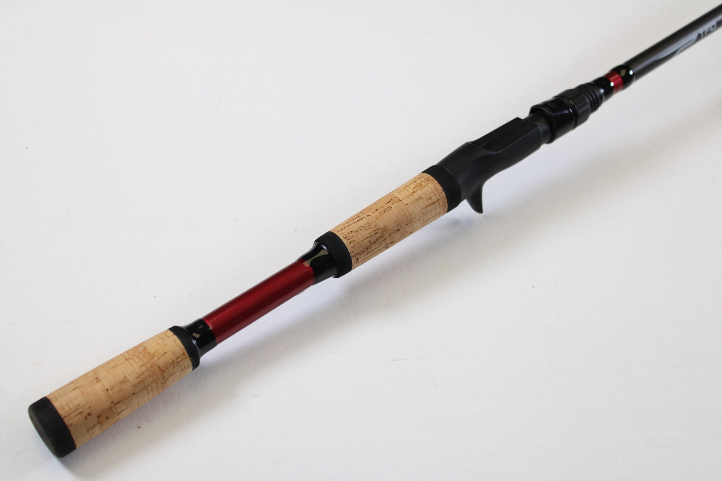 Upgrade with our Rod and Reel Trade-In Program: Temple Fork TFO Tactical Glass Bass TACGBCB745-1 7'4" Medium Heavy Used Casting Rod in excellent condition, featuring a cork handle and red accent, shown on a plain white background.