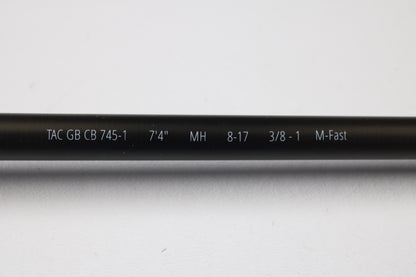 A close-up of a Temple Fork TFO Tactical Glass Bass TACGBCB745-1 7'4" Medium Heavy Used Casting Rod in excellent condition displays its white specs for easy ID as part of our Rod and Reel Trade-In Program.