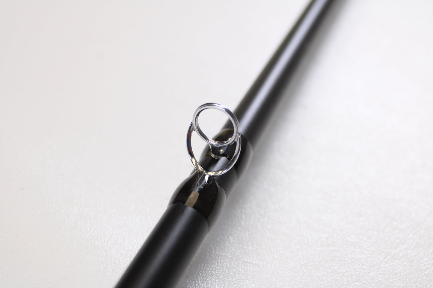 A close-up of the Temple Fork TFO Tactical Glass Bass TACGBCB745-1 7'4" Medium Heavy, highlighting a metal line guide—ideal for featuring this used casting rod in excellent condition in our Rod and Reel Trade-In Program.