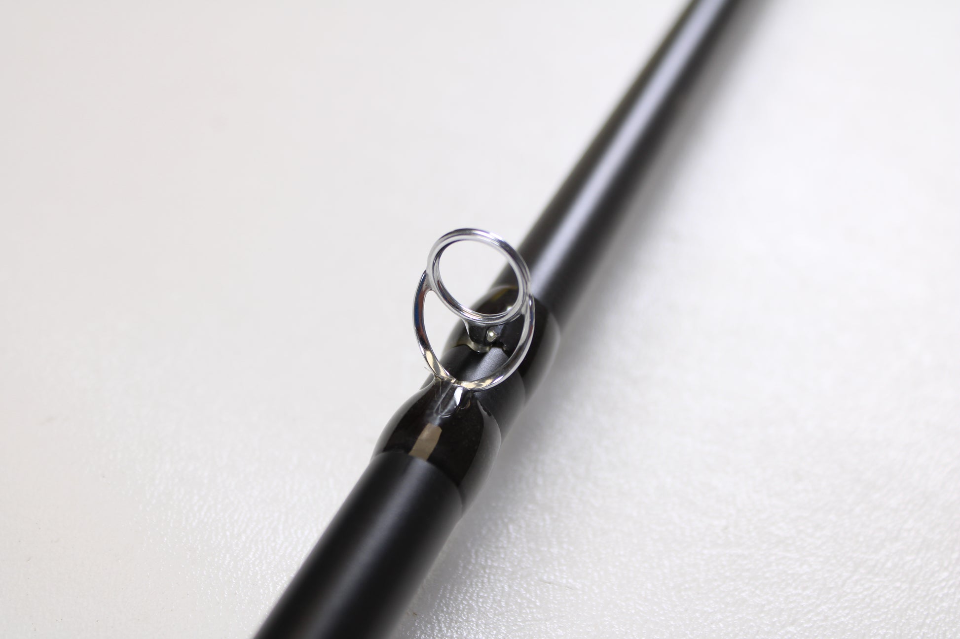 A close-up of the Temple Fork TFO Tactical Glass Bass TACGBCB745-1 7'4" Medium Heavy, highlighting a metal line guide—ideal for featuring this used casting rod in excellent condition in our Rod and Reel Trade-In Program.