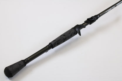 A close-up of the Temple Fork TFO Tactical Elite Bass TLE SC 747-1 7'4" Ex-Heavy casting rod handle—black with a textured grip and trigger reel seat—shows this quality used gear, ideal for anglers trading in rods and reels.