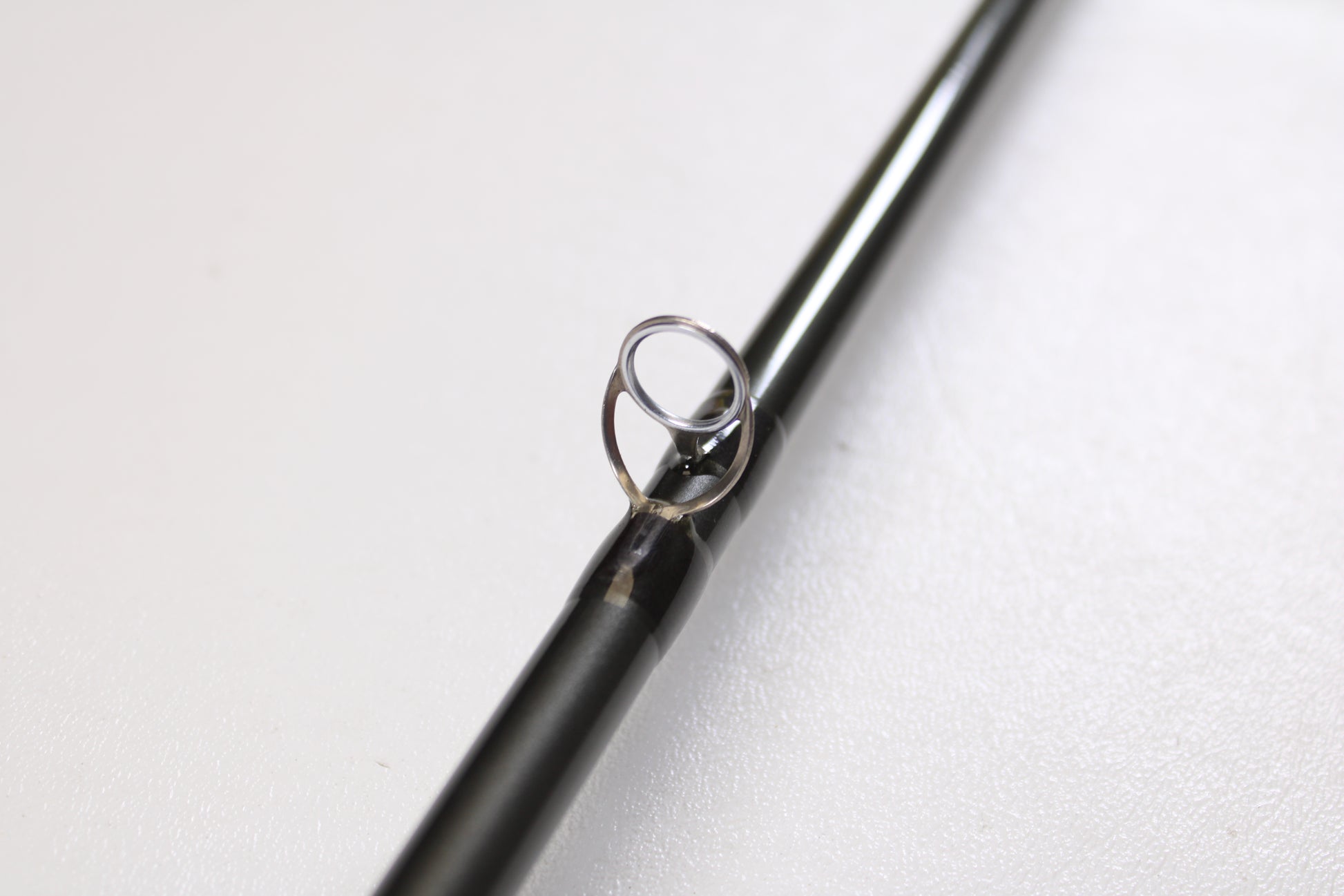 A close-up of the Temple Fork TFO Tactical Elite Bass TLE SC 747-1 7'4" Ex-Heavy Used Casting Rod in excellent condition, featuring a metal guide ring, photographed on a plain white surface.