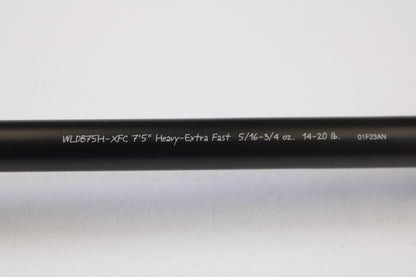 A close-up of the Fenwick World Class Bass WLDB75H-XFC 7'5" Heavy used casting rod in excellent condition, featuring white specs on a black blank, photographed against a white background and eligible for our rod and reel trade-in program.