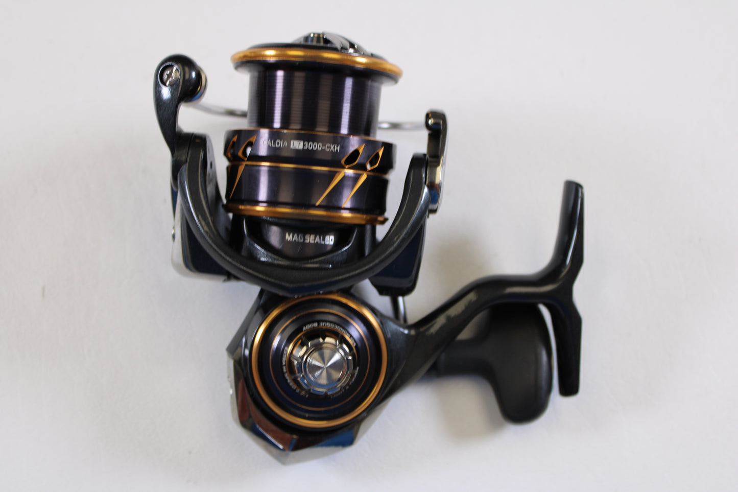 A close-up of a Daiwa Caldia LT 3000-CXH (Used Spinning Reel, Very Good Condition) from our Rod and Reel Trade-In Program, featuring a visible handle, spool with dark line, and metallic details by Daiwa on a white background.