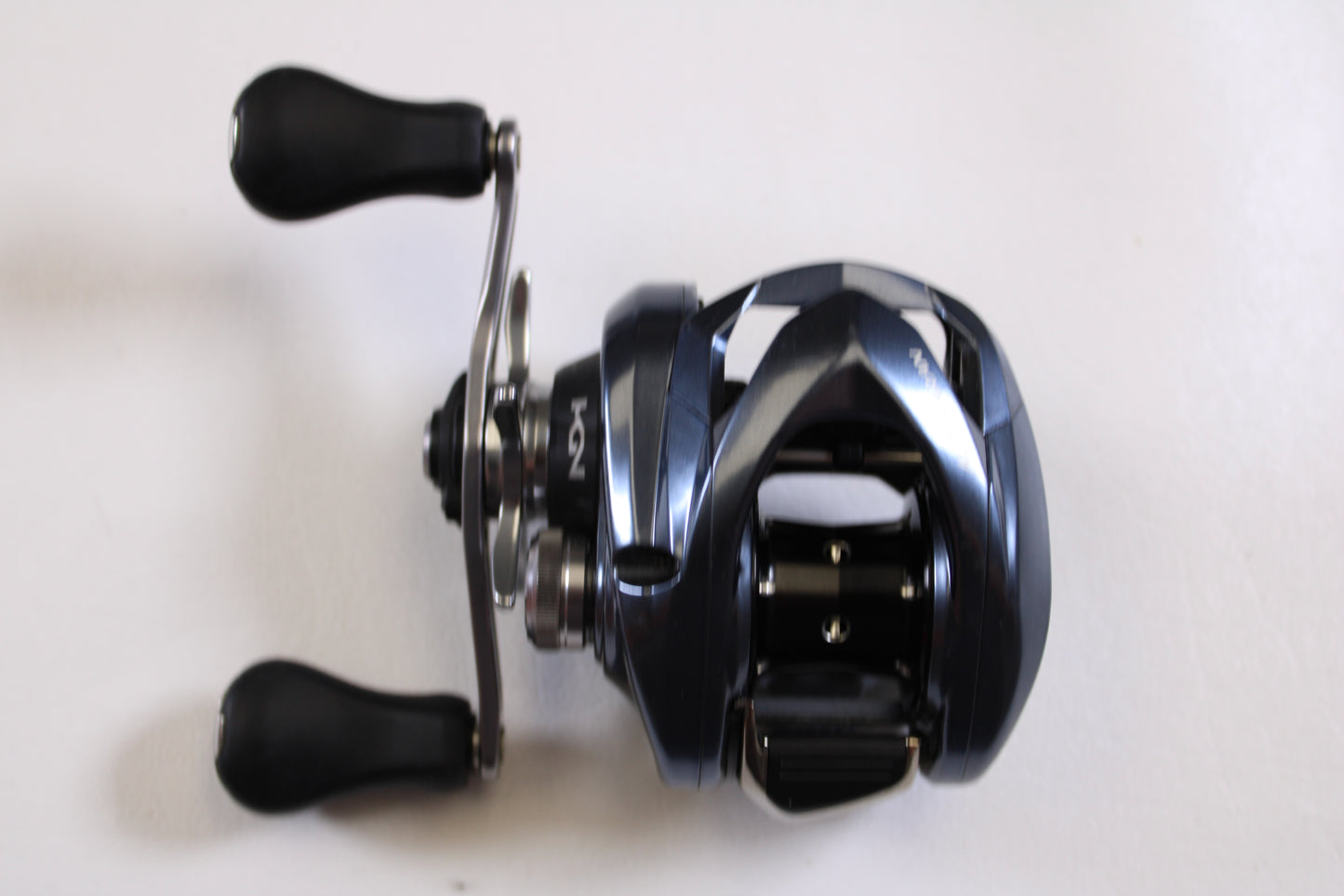 A close-up of the Shimano Aldebaran MGL ALDMGL51 6.5:1 LH Used Casting Reel in very good condition, featuring two black handles—ideal for upgrading as part of our Rod and Reel Trade-In Program.