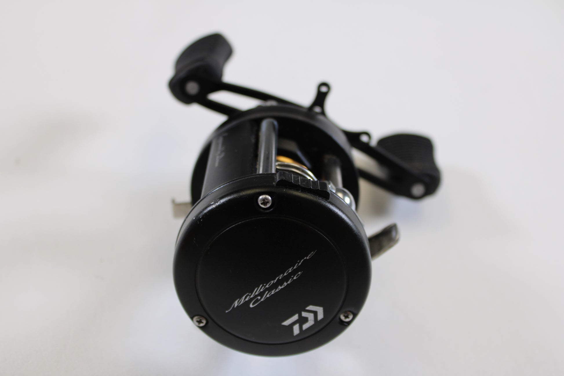 A used Daiwa Millionaire Classic UTD M-CUTD250L 5.1:1 LH casting reel in good condition is shown on a white background—ideal for upgrading through our Rod and Reel Trade-In Program or earning store credit for your used fishing gear.