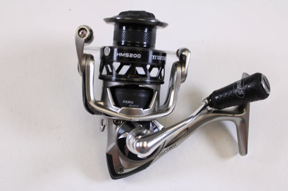 A close-up of a Lew's HyperMag HMS200 6.2:1 used spinning reel in fair condition (missing handle nut) is displayed on a white surface—ideal for upgrading via our rod and reel trade-in program for store credit on used gear.