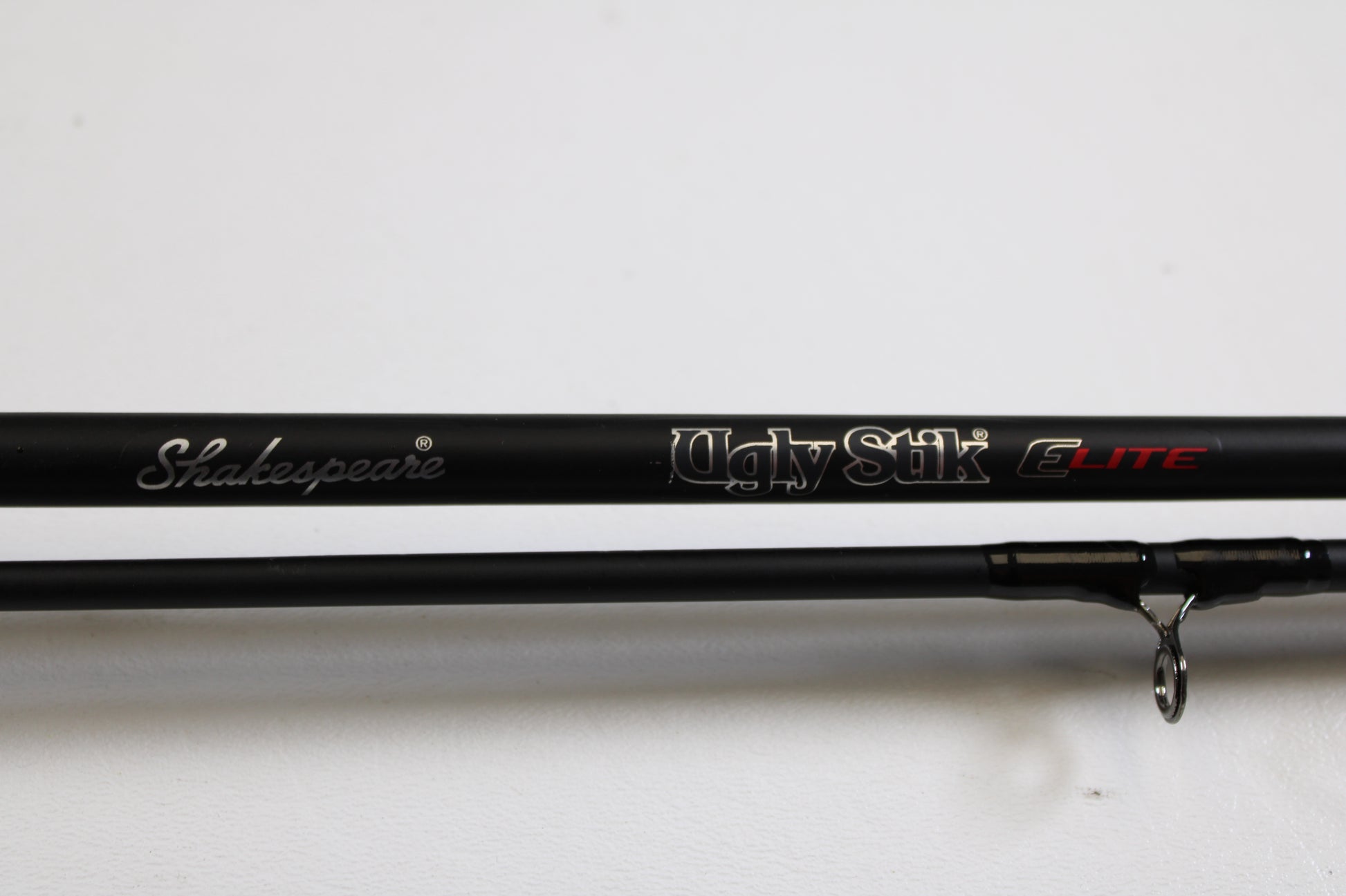 Close-up of a black Shakespeare Ugly Stik Elite Salmon/Steelhead USESCA862M 8'6" Medium 2 Piece used casting rod in excellent condition, available in Qty: 2—ideal for those trading in gear for store credit through our Rod and Reel Trade-In Program.