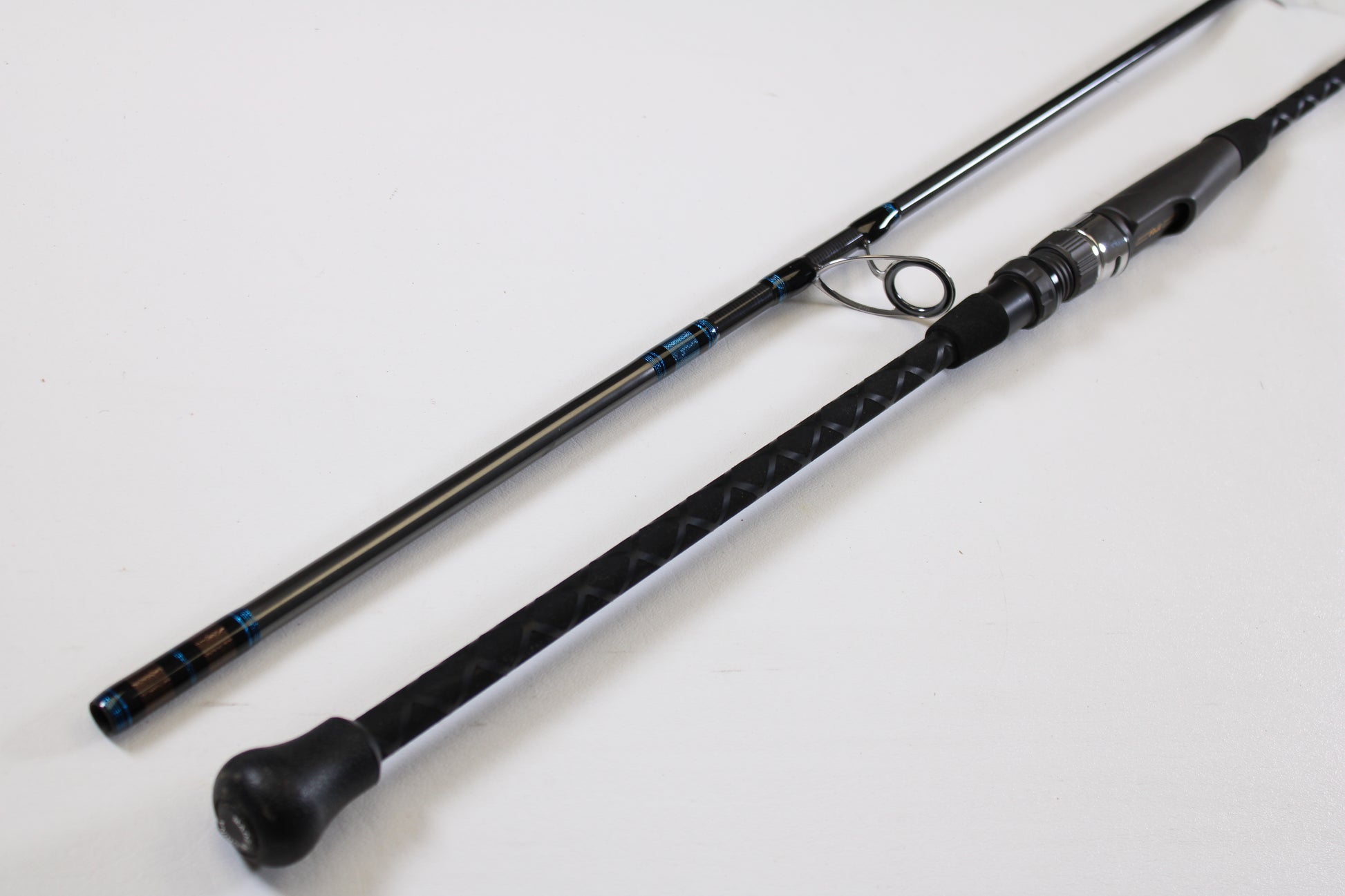 A close-up of the Tsunami Airwave Elite TSAWESS762LT 7'6" 2-piece used spinning rod in excellent condition, highlighting its textured handle and components—ideal for anglers seeking quality pre-owned gear or trade-in options.