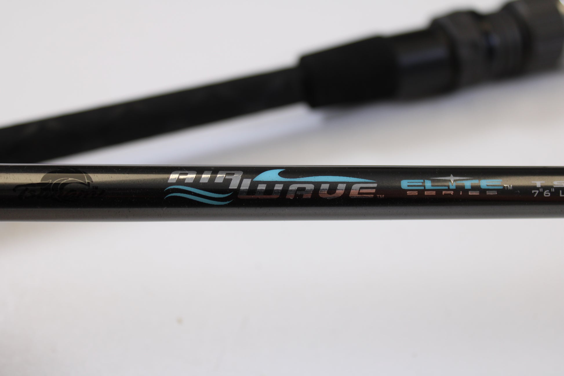 Close-up of the Tsunami Airwave Elite TSAWESS762LT 7'6" 2 Piece Used Spinning Rod in excellent condition, showing "Airwave Elite Series" text—ideal for our trade-in or used gear store credit offers.