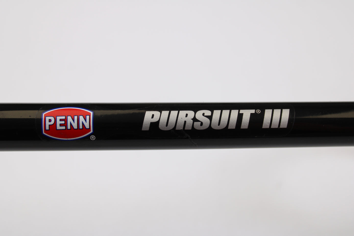 A close-up of the Penn Pursuit III PUTIII1530S70H 7'0" Heavy used spinning rod in excellent condition, featuring the Penn logo and "PURSUIT III" text on a black finish—ideal for upgrading through our rod and reel trade-in program.