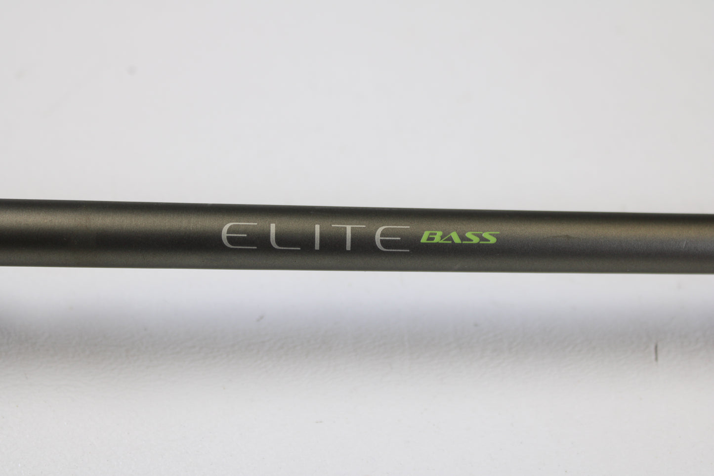 A close-up of the Fenwick Elite Bass ELTB70MH-FC 7'0" Medium Heavy Used Casting Rod, in very good condition, featuring "ELITE" in white and "BASS" in green on a black rod against a plain white background. Ideal for used gear or trade-in shoppers.