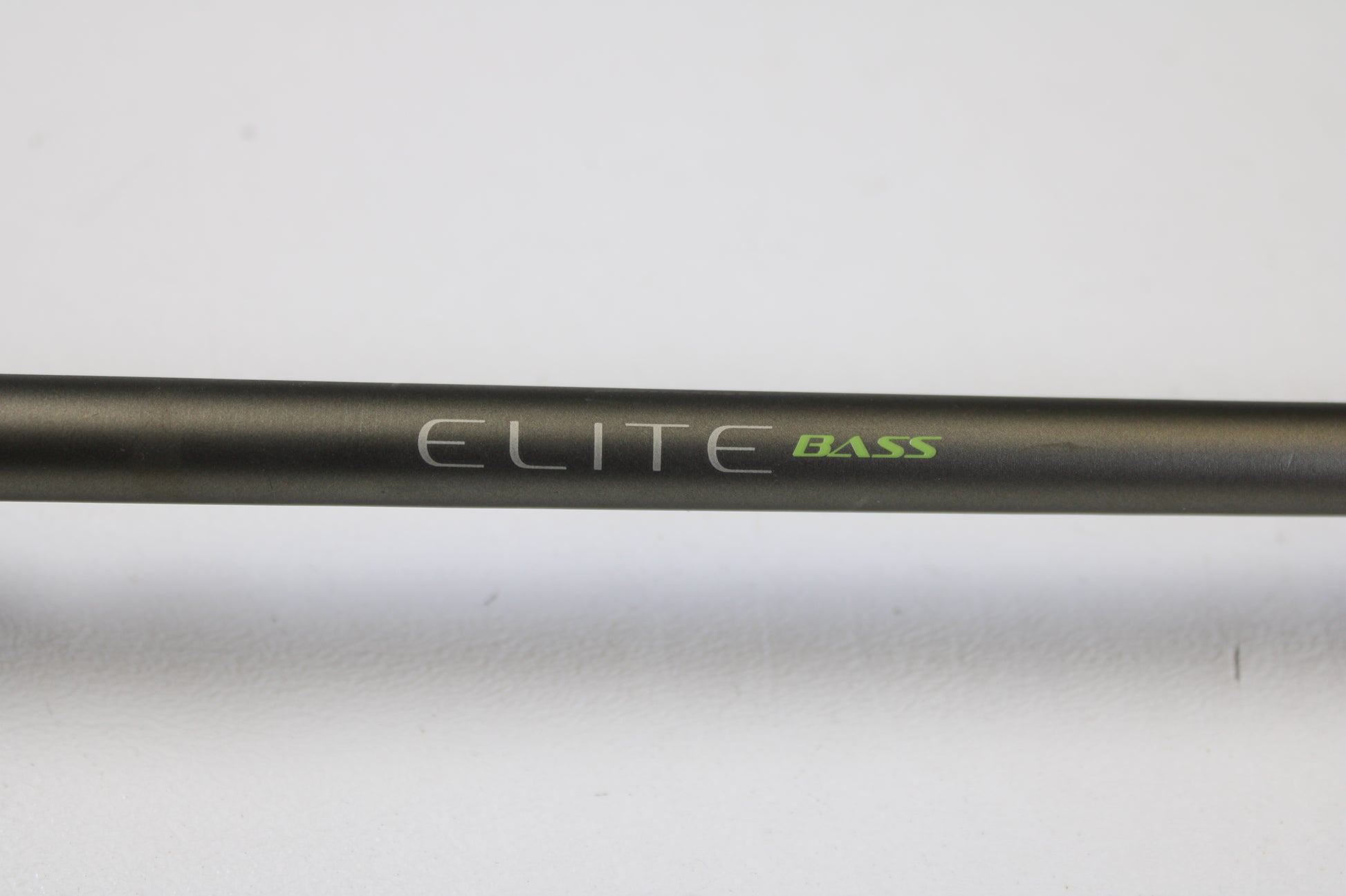 A close-up of the Fenwick Elite Bass ELTB70MH-FC 7'0" Medium Heavy Used Casting Rod, in very good condition, featuring "ELITE" in white and "BASS" in green on a black rod against a plain white background. Ideal for used gear or trade-in shoppers.