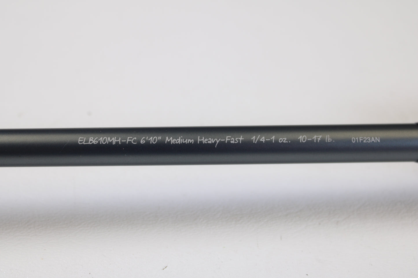 A Fenwick Elite Bass ELB610MH-FC 6'10" Medium Heavy used casting rod in very good condition, featuring white model details on a black finish, ideal for rod and reel trade-ins. Shown on a white surface.
