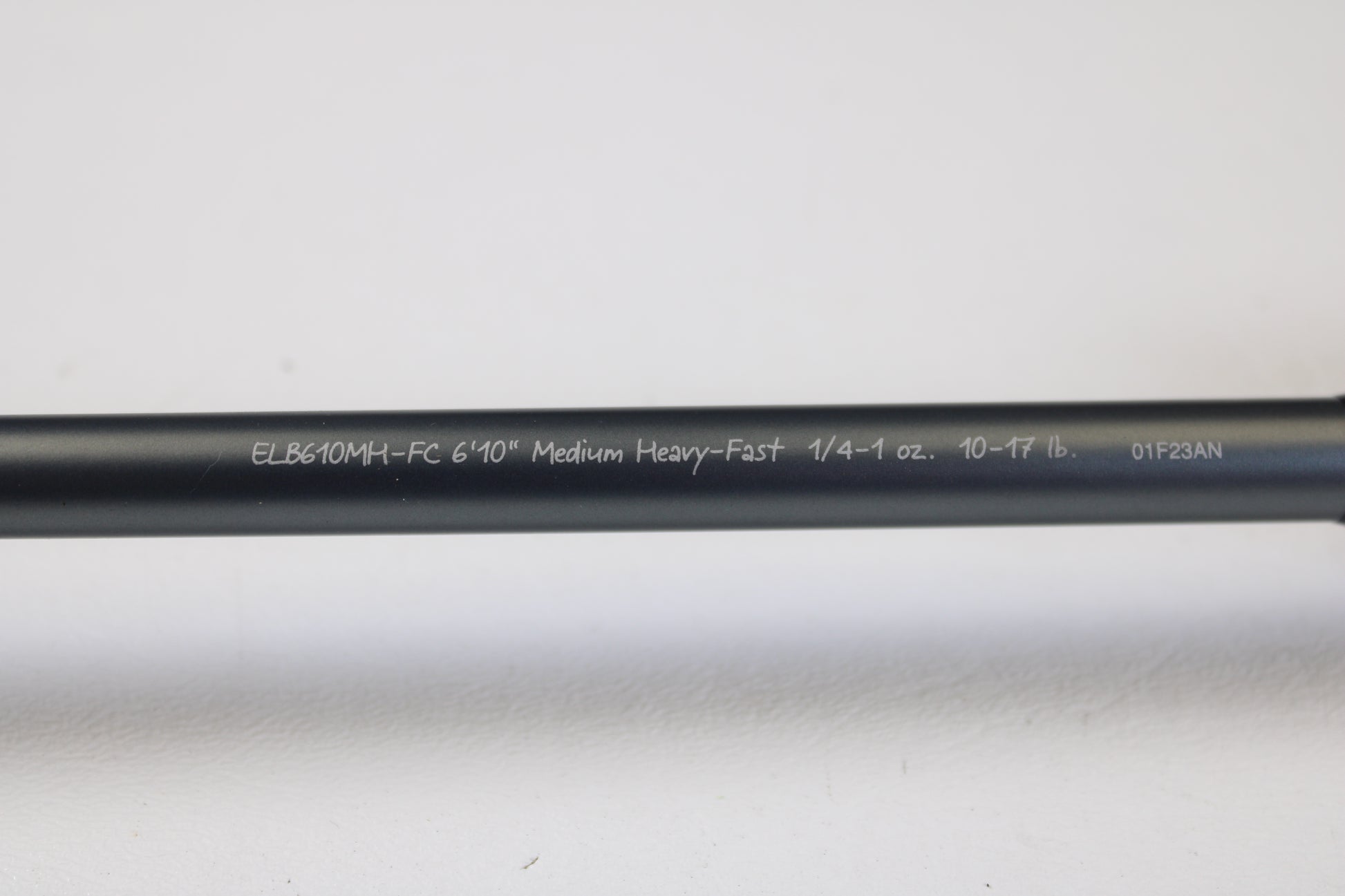 A Fenwick Elite Bass ELB610MH-FC 6'10" Medium Heavy used casting rod in very good condition, featuring white model details on a black finish, ideal for rod and reel trade-ins. Shown on a white surface.