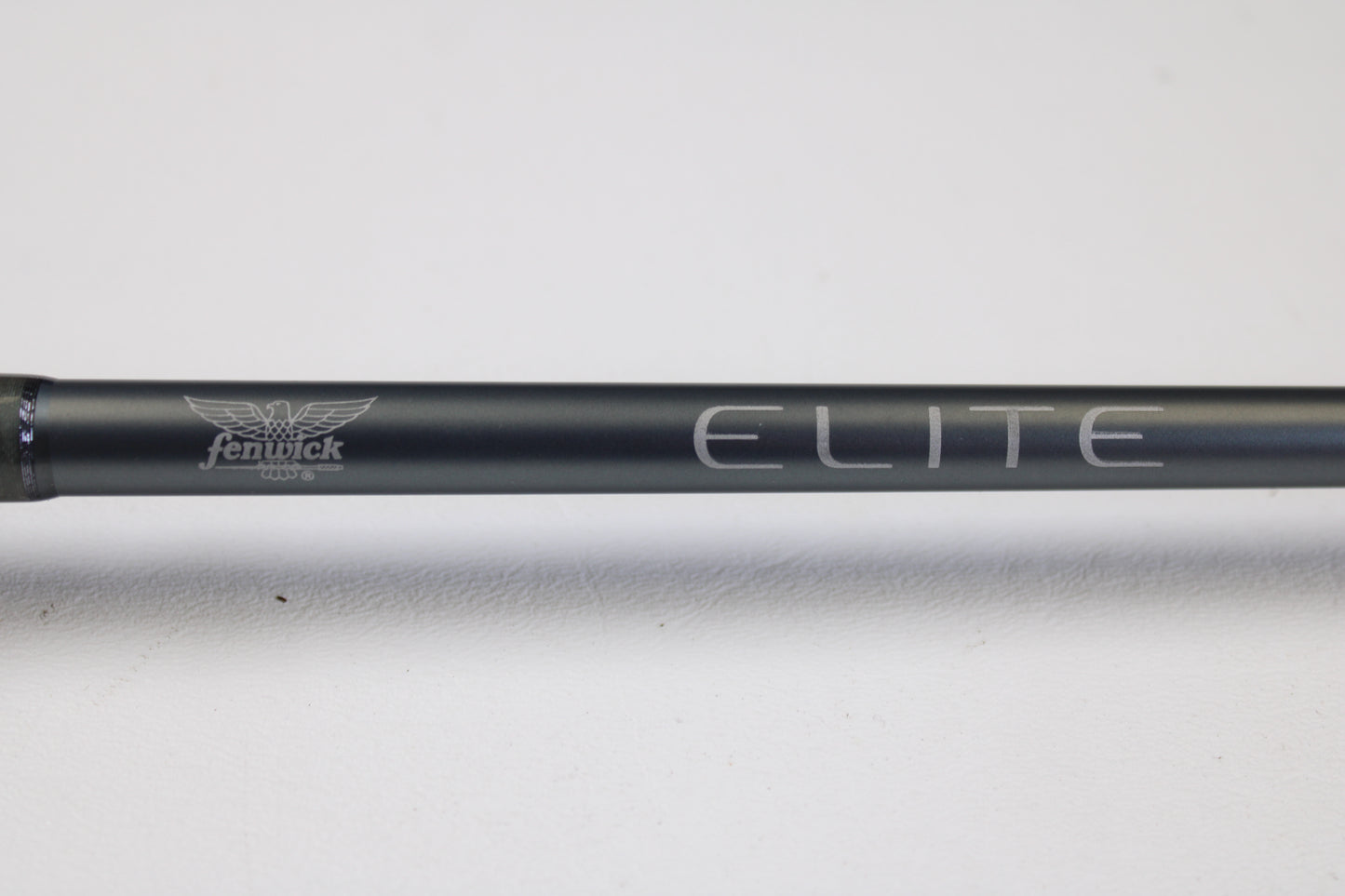A close-up of the Fenwick Elite Bass ELB610MH-FC 6'10" Medium Heavy Used Casting Rod in very good condition, featuring the "Fenwick" and "ELITE" logos—ideal for those considering our rod and reel trade-in program or used gear.