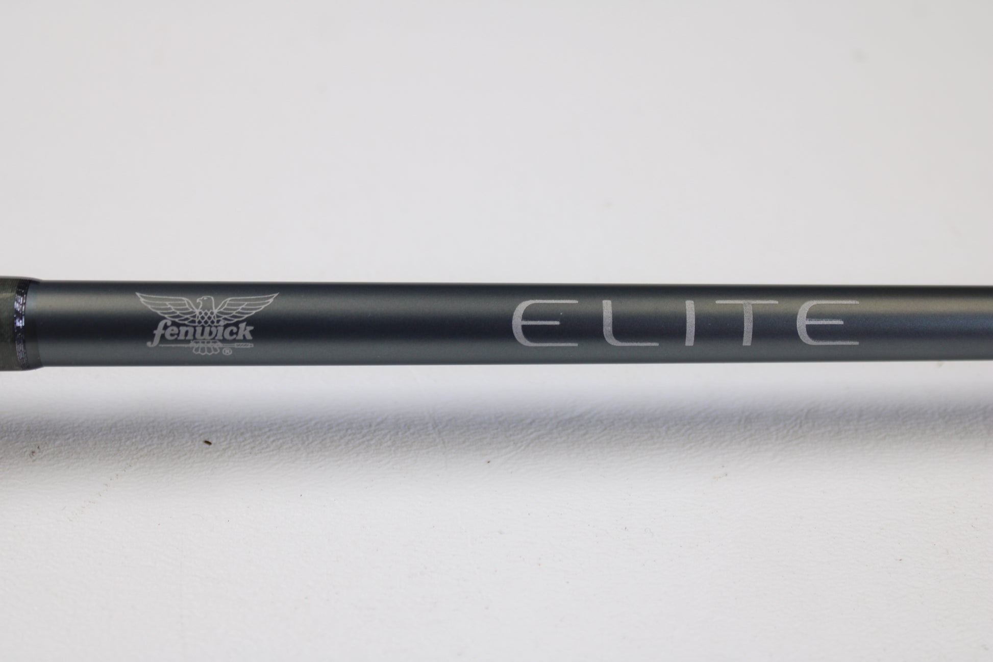 A close-up of the Fenwick Elite Bass ELB610MH-FC 6'10" Medium Heavy Used Casting Rod in very good condition, featuring the "Fenwick" and "ELITE" logos—ideal for those considering our rod and reel trade-in program or used gear.