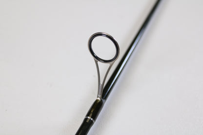 A close-up of the St. Croix Legend Elite Panfish LEP69LF 6'9" Light used spinning rod highlights a guide ring on its glossy black surface—promoting our Rod and Reel Trade-In Program: turn your used gear into store credit. Shot on a plain white background.